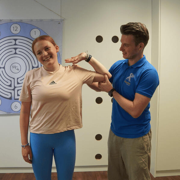 Neuroathletik Physiotherapie Kevin Grafen macht eine Nervenmobilisation des Nervus ulnaris mit einer Patientin.